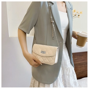 Détail d'un sac bandoulière matelassé crème avec chaîne argentée et boucle