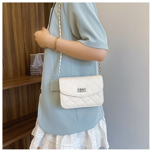 Gros plan d'un sac bandoulière blanc matelassé avec chaîne argentée sur un modèle