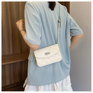 Détail du sac bandoulière blanc matelassé avec chaîne argentée et breloques boules