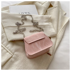 Detailed shot of pink leather mini bag with marble texture and silver chain strap