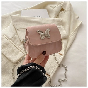 Detail of pink mini chain bag with glossy finish and silver butterfly buckle