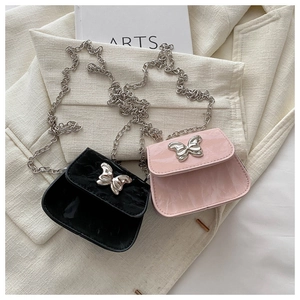 Detail of mini lipstick bags in black and pink with butterfly buckles and silver chains