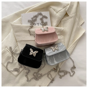 Macro detail of glossy marble texture and metal butterfly buckle on mini chain bags