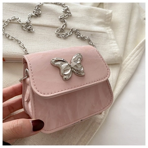 Close-up of mini pink lipstick bag with metallic butterfly buckle and silver chain strap