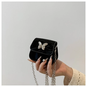 Detailed macro view of mini black velvet crossbody bag with silver butterfly buckle