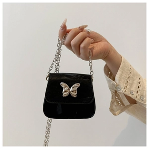 Detail of a mini black crossbody bag featuring a large silver butterfly metal buckle