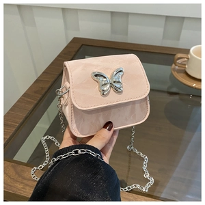 Detail of light pink mini crossbody bag featuring a silver butterfly clasp and chain strap