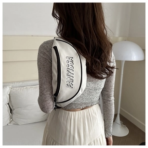 Detailaufnahme der weißen Crossbody-Tasche mit schwarzem Schriftzug am Rücken