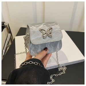 Detailed view of silver mini chain bag with metallic texture and butterfly clasp buckle