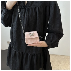 Detail of pink marble textured mini bag with silver butterfly buckle and chain strap