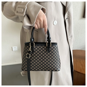 Detailansicht einer Vintage-Tasche mit braunem geometrischem Muster und goldener Hardware