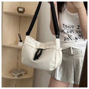 Détail du sac bandoulière en nylon blanc avec cordon noir et large sangle tissée