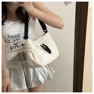 Détail du sac bandoulière blanc en nylon avec cordon de serrage et nœud noir décoratif