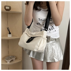 Détail du sac à bandoulière blanc cassé avec sangle noire réglable et cordon de serrage