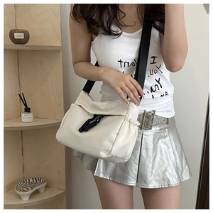 Détail du sac bandoulière en nylon blanc avec sangle contrastée et cordon tressé
