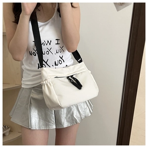 Détail d'un sac bandoulière blanc en nylon avec sangle noire et cordon de serrage