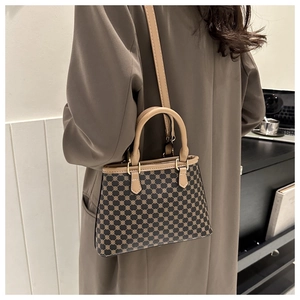 Französische Vintage-Mini-Tasche mit Monogramm-Muster, getragen über einem braunen Mantel