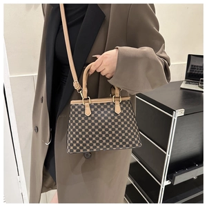 Detailansicht der Vintage-Trapeztasche mit goldenen geometrischen Mustern und Lederriemen