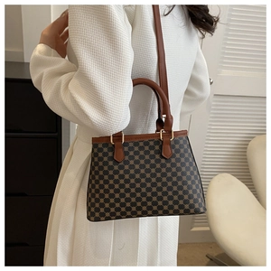Detail der Vintage-Tasche mit geometrischem Muster und braunen Lederriemen