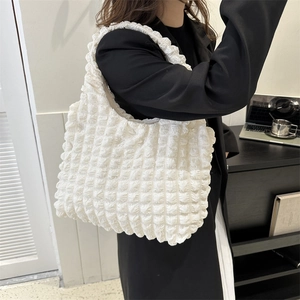 White popcorn textured cloud pleated tote bag with single shoulder strap on model