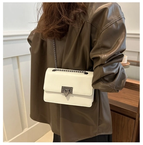 Detail of off-white crossbody bag featuring arrow metal clasp and chain strap
