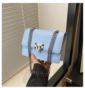 Close-up of light blue crossbody bag with silver industrial lock and chain strap