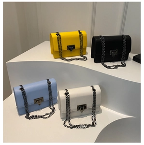 Collection of vibrant square crossbody bags with metallic chains in yellow, black, and blue