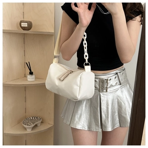 Detail of cream pillow crossbody bag with chunky acrylic chain and wide shoulder strap