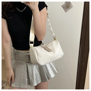Mirror selfie showing the off-white half-moon crossbody bag with decorative plastic chain