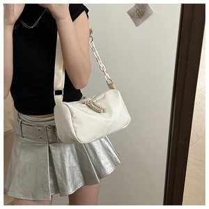 Mirror selfie showing a cream-colored PU shoulder bag with chain and wide strap detail