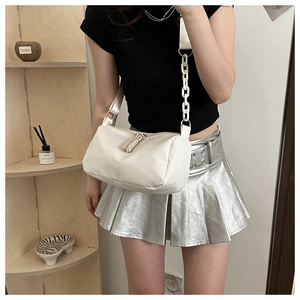 Detail of white nylon crossbody bag with woven strap and decorative white chain accessory