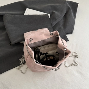 Bolso saco de ante rosa con cadena metálica que muestra capacidad y textura suave