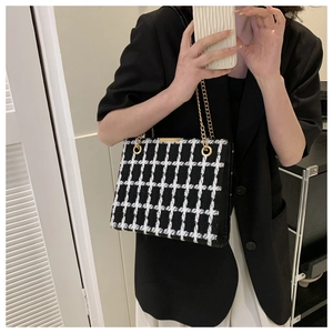 Detail view of monochrome plaid tweed shoulder bag with elegant gold chain straps