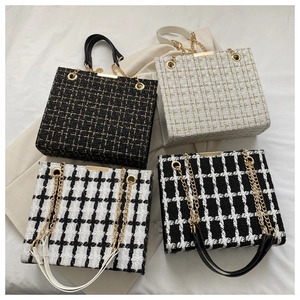 Detail view of four tweed tote bags with gold chains in various plaid patterns