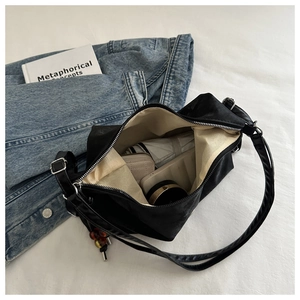 Internal view of black tote bag showing spacious storage for wallet and umbrella