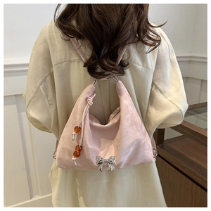 Pink suede crescent bag detail with silver bow accent and amber bead tassel charm