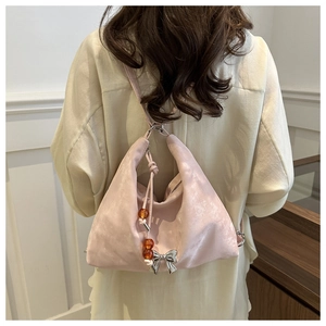 Close-up of pink satin backpack with silver bow and amber bead charm detail