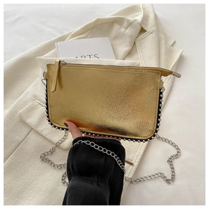 Detail of golden crackle-texture handbag with silver bead trim and metallic chain strap