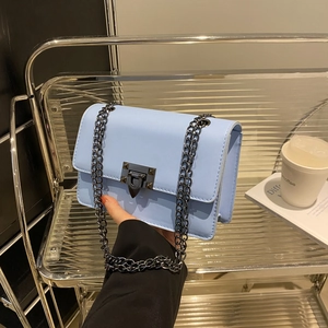 Minimalist light blue leather flap crossbody bag with metal chain strap and twist lock