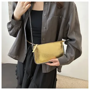Close-up of metallic yellow mini crossbody bag with silver bead trim and chain strap