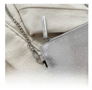 Detail of silver metallic handbag texture with polished metal chain and lobster clasp hooks