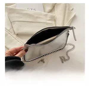 Detail of silver metallic crossbody bag showing interior capacity for a smartphone