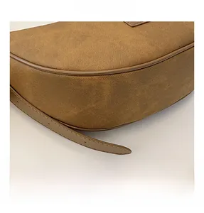 Close-up of the textured brown dumpling bag showing durable synthetic leather and fine stitching
