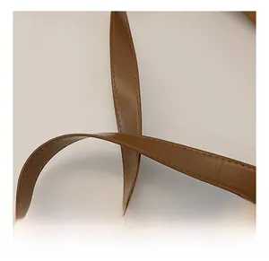Detail of brown leather shoulder strap with neat stitching and soft folded texture