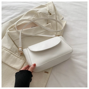 Detailed view of white minimalist square crossbody bag with gold hardware and strap