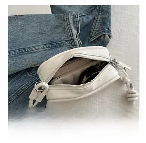 Internal storage of small white leather crossbody bag with braided rope strap