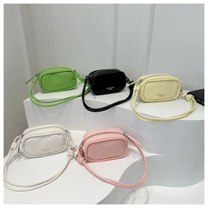Group shot of five colorful mini crossbody bags in soft PU leather on white geometric stands