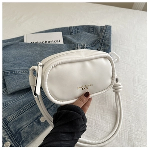 Detail of a white PU leather small crossbody bag with gold logo and round rope shoulder strap