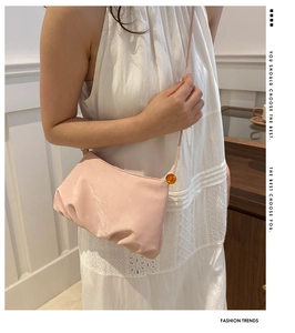 Détail du sac nuage plissé rose clair avec accent de perle orange sur la bandoulière