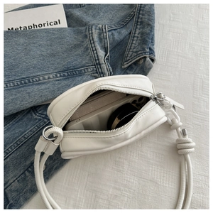Internal view of a white leather crossbody bag with items showing storage capacity